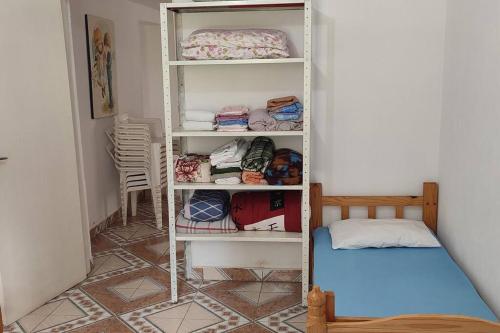 Zimmer mit einem weißen Regal und einem Bett in der Unterkunft Casa de campo com piscina em condomínio. in Ibiúna