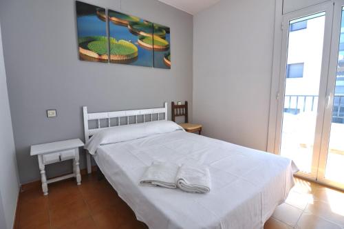 a bedroom with a bed with two towels on it at RNET - MTA Apartaments A3 in Roses