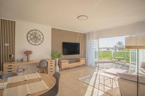 a living room with a clock on the wall at Buenti Apartments Beach Beautiful view in Marbella