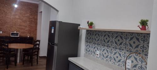 a kitchen with a refrigerator and a table with chairs at Fazenda São Miguel in Monte Alegre do Sul