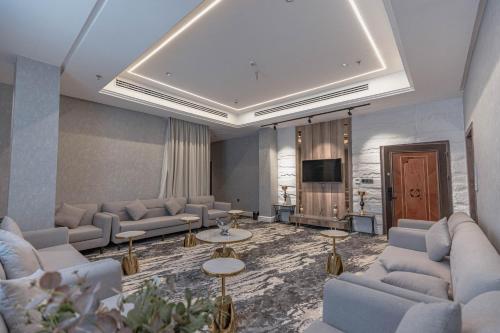 uma sala de estar com sofás e uma televisão de ecrã plano em فندق ماسة المشاعر الفندقية em Meca