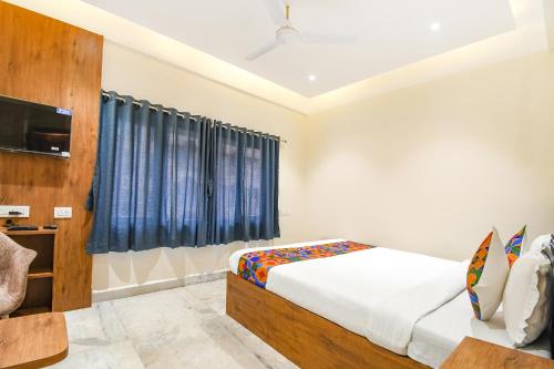 a bedroom with a bed and a tv in a room at FabHotel Prime The Golden Plaza - Nr Tarapith Temple in Tarapith