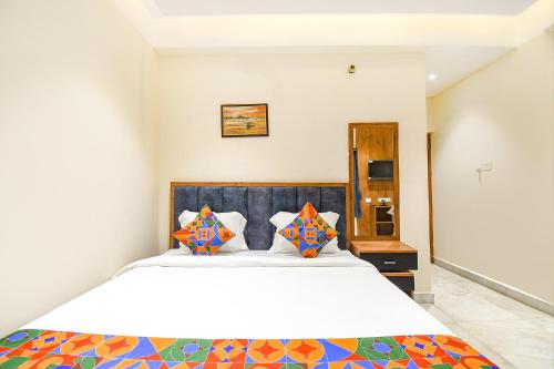 1 dormitorio con 1 cama blanca grande con almohadas coloridas en FabHotel Prime The Golden Plaza, en Tarapith
