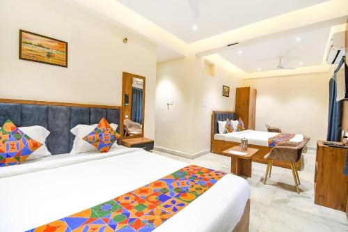 a hotel room with two beds and a desk at FabHotel Prime The Golden Plaza in Tarapith