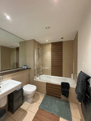 a bathroom with a tub and a toilet and a sink at City Centre 1 bedroom apartment in Manchester