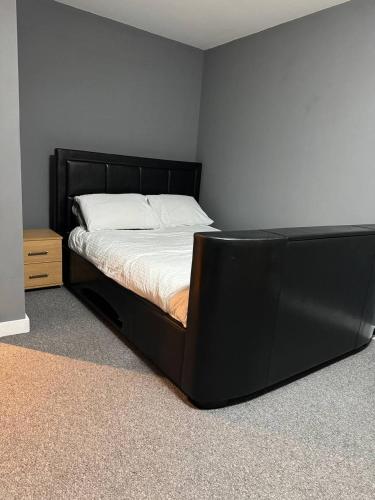 a bed with a black frame in a room at City Centre 1 bedroom apartment in Manchester