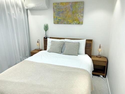 a bedroom with a white bed and a painting on the wall at Comma 2, Cozy Semi-basement in Seoul