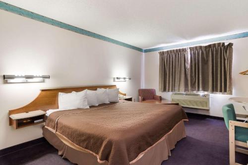 een hotelkamer met een groot bed en een raam bij Rodeway Inn in Gallup