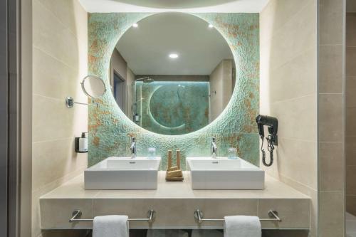 a bathroom with two sinks and a mirror at Occidental Puerto Banús in Marbella