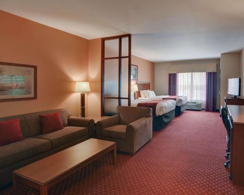 a hotel room with a couch and a bed at Quality Suites Near Cedar Creek Lake in Mabank