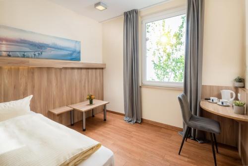 ein Hotelzimmer mit einem Bett, einem Schreibtisch und einem Fenster in der Unterkunft Hotel Neumarkt in Berg bei Neumarkt