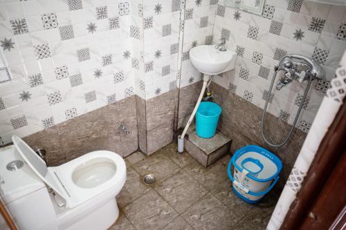 a bathroom with a toilet and a sink at Goroomgo YP Stays Dehradun - Parking facilities - Best Seller in Dehradun