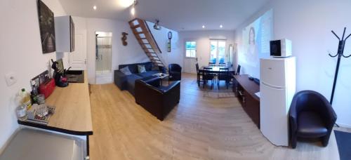 - un salon avec un canapé bleu et un escalier dans l'établissement Gites Au ChAtÔ et la Paillote en baie de somme, à Quend