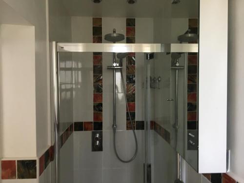 a bathroom with a shower with a glass door at Barn Corner in Bridport