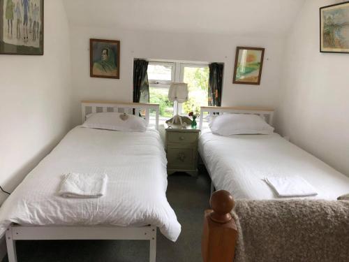two beds sitting next to each other in a bedroom at Barn Corner in Bridport