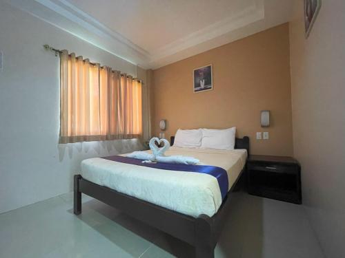 Un dormitorio con una cama con una toalla. en Argao Seabreeze Hotel powered by Cocotel, en Argao
