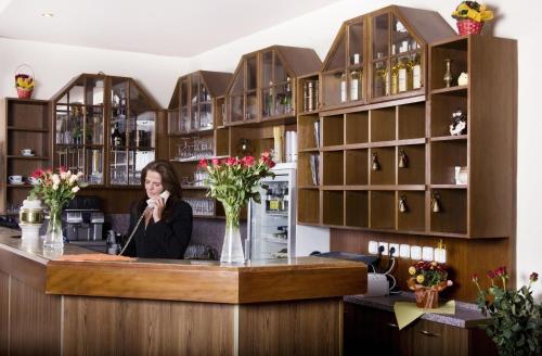 Una donna che parla al telefono in un bar in una stanza di Hotel Saint Antonius a Mariánské Lázně