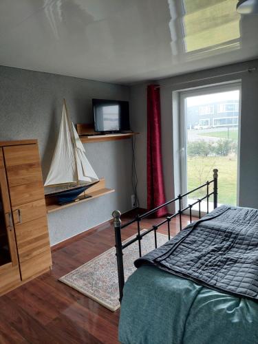 a bedroom with a bed and a tv and a window at Erlgrund in Erfurt