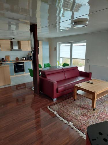 愛爾福特的住宿－Erlgrund，客厅配有红色的沙发和桌子