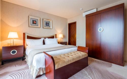 a bedroom with a large bed and a wooden cabinet at Dreamland Oasis Hotel Chakvi in Chakvi