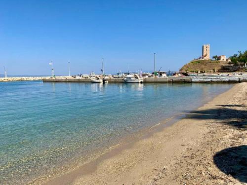 a sandy beach with boats in the water at Seashell by halu! in Nea Fokea