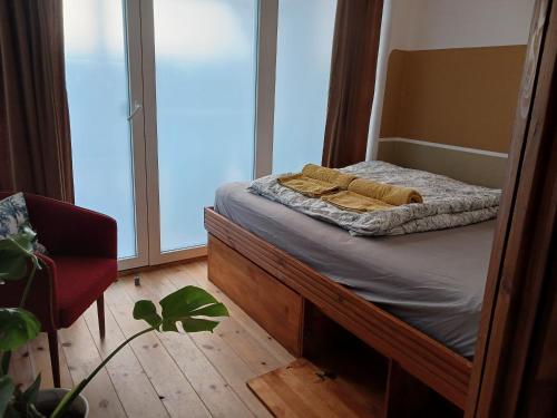 Bett in einem Zimmer mit einem großen Fenster in der Unterkunft Squat Deluxe Berlin, the hostel in Berlin