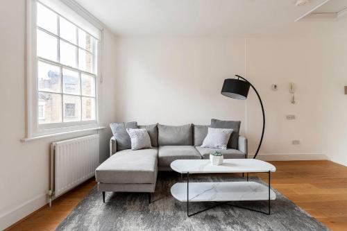 ein Wohnzimmer mit einem Sofa und einem Tisch in der Unterkunft Bright Marylebone Apartment in London