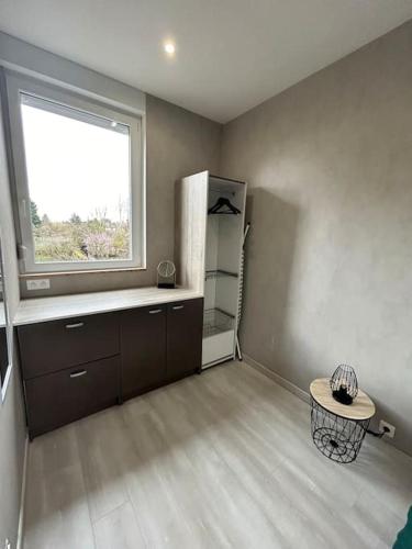 Il comprend une cuisine équipée d'un réfrigérateur et d'une fenêtre. dans l'établissement Martine: appartement 1er étage, à Cambrai