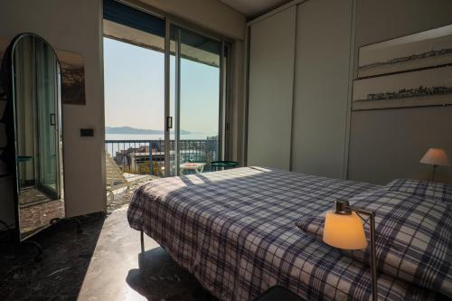 a bedroom with a bed and a view of the ocean at L’Attico di Susanna in Verbania