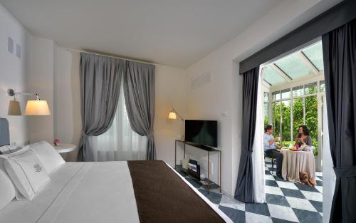 a hotel room with a bed and people sitting at a table at Villa Amagioia by Palazzo di Varignana in Varignana