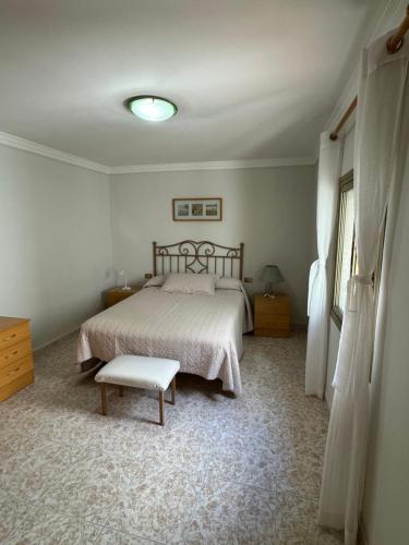 a bedroom with a bed and a bench in it at Casa Pepa in Puerto de Mogán