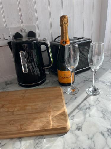a bottle of champagne and two wine glasses on a counter at COLE HOUSE in Solihull
