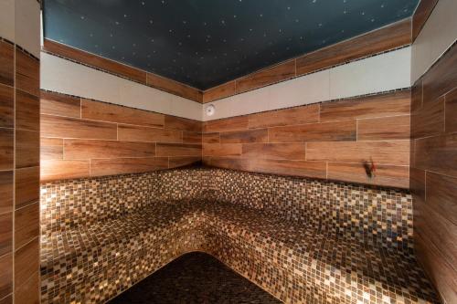 a bathroom with a bath tub with wood tiles at Le Domaine du Verger gîtes et SPA in Osenbach