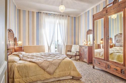 - une chambre avec un grand lit et un miroir dans l'établissement Casa delle Rose - Together in Tuscany, à Cortone