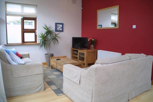 Una sala de estar con dos sofás y un televisor. en Bright spacious mews in great location, en Booterstown