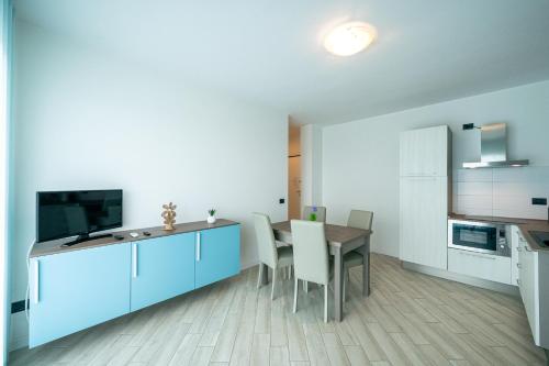 a kitchen and dining room with blue cabinets and a table at Milena Suite Apartments in Alghero