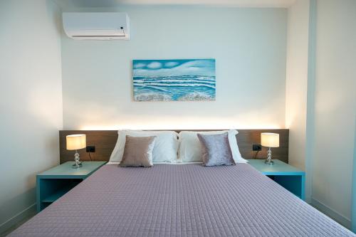 a bedroom with a bed with two blue tables at Milena Suite Apartments in Alghero