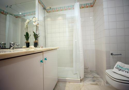 uma casa de banho com um WC, um lavatório e um chuveiro em A65 - Marina Moor Apartment in Lagos em Lagos