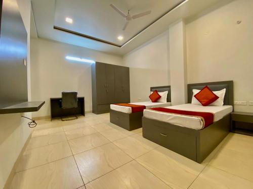 a room with two beds and a tv in it at hello Namaste India-Elite in Jaipur