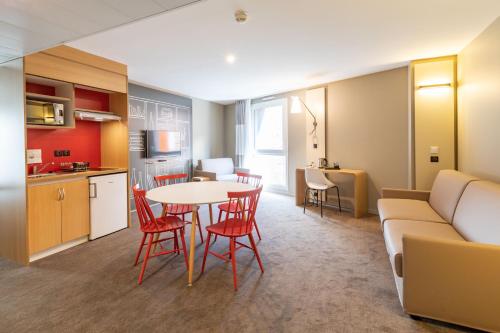 a kitchen and a living room with a table and chairs at ibis Saint Malo Plage in Saint Malo