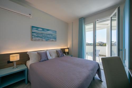 a bedroom with a bed and a large window at Milena Suite Apartments in Alghero