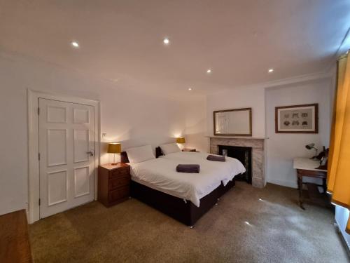 a bedroom with a large bed and a fireplace at Firkinn in London