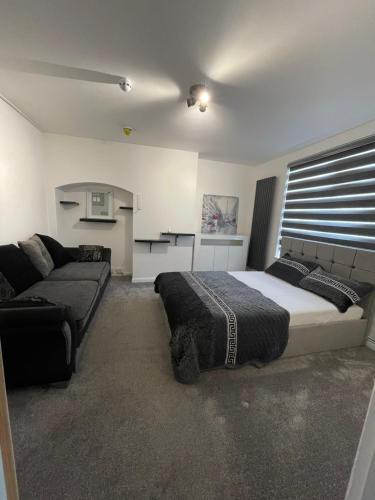 um quarto com uma cama e um sofá em UPPAMOST London luxury home 2 em Dagenham