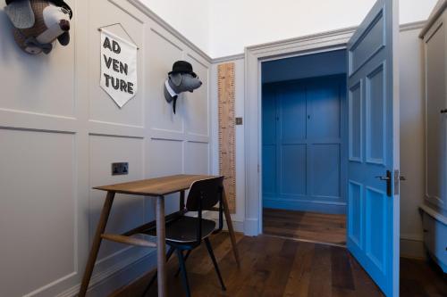 a room with a table and a blue door at Fowey Hall Hotel in Fowey