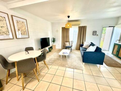 ein Wohnzimmer mit einem blauen Sofa und einem Tisch in der Unterkunft 'Your Place on Davidson' in Mount Isa
