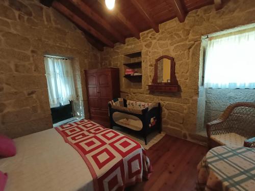 - une chambre avec un lit dans une pièce en pierre dans l'établissement Casa Uma Turismo Rural, à Taboeja
