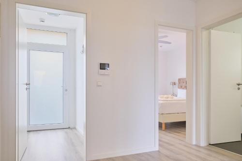 een witte kamer met een deur en een slaapkamer bij H24 Factory Apartments Wolfsburg in Wolfsburg