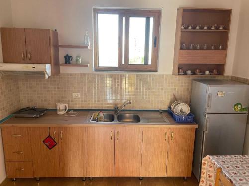 a kitchen with a sink and a refrigerator at Happy Corner Guest House in Shkodër