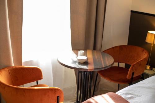 une pièce avec deux chaises, une table et un lit dans l'établissement Loire - Hypercentre, à Orléans