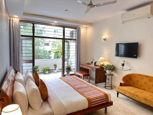 um quarto com uma cama grande e uma televisão em Grove Residency Hauz Khas New Delhi Couple Friendly em Nova Deli